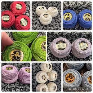 May include: A selection of DMC pearl cotton thread balls in shades of red, white, blue, green, and lilac. Each ball is labelled with its colour number and brand details. The thread is suitable for embroidery and other crafts.
