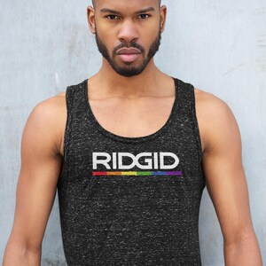 May include: Black tank top with the word "RIDGID" in white letters and a rainbow stripe underneath. The tank top is worn by a person with a shaved head and a beard.