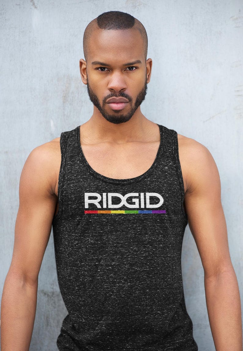 May include: Black tank top with the word "RIDGID" in white letters and a rainbow stripe underneath. The tank top is worn by a person with a shaved head and a beard.