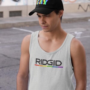 May include: Black baseball cap with the word "GAY" in rainbow colors. A light gray tank top with the word "RIDGID" in black and a rainbow stripe underneath.