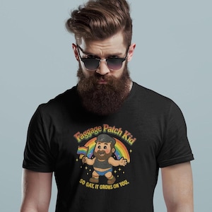 May include: Black t-shirt with a cartoon design of a character holding a rainbow flag, with the text "Faggage Patch Kid" and "So gay, it grows on you". The design includes a rainbow and stars.