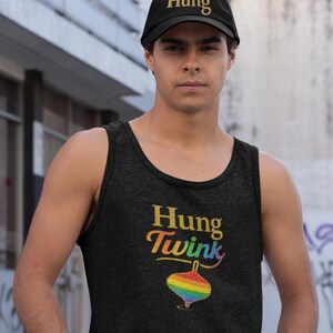 May include: A black baseball cap with the word "Hung" in gold lettering. The person is wearing a black tank top with the words "Hung Twink" in rainbow colors and a rainbow-colored spinning top graphic.