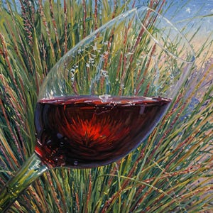 May include: A wine glass filled with red wine, set against a backdrop of tall green and brown grasses. The glass is clear, and the wine reflects the surrounding environment. The scene evokes a sense of nature and leisure.