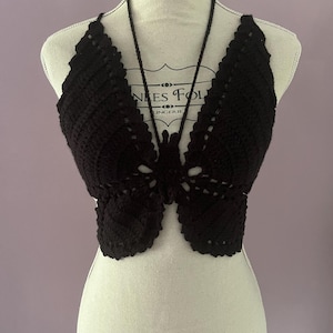 Peut inclure: Top court en crochet noir en forme de papillon avec un style halter.