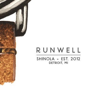 Puede incluir: Primer plano de una correa de cuero marr&oacute;n con una hebilla plateada. La correa est&aacute; unida a un reloj con el texto "RUNWELL SHinola - EST. 2012 DETROIT, MI" impreso en la esfera.