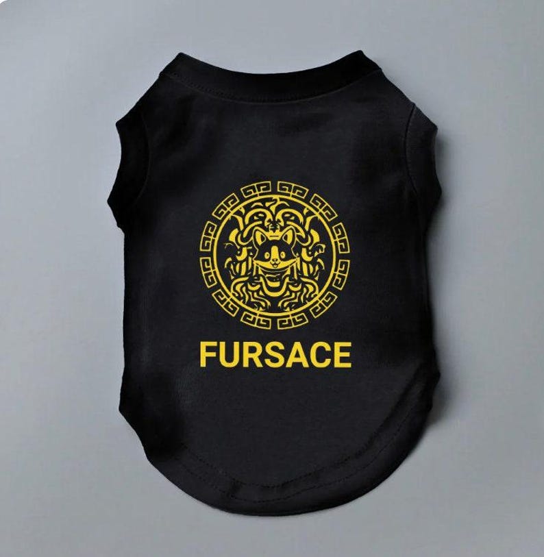 Black Dog shirt with the word FURSACE printed on it in yellow. The face in the logo is of a dog, incorporating dog ears and a smiling expression. The T-Shirt is designed for dogs, playing on the designer fashion brand in a humorous way.