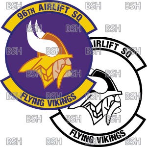 May include: A purple and yellow emblem with a Viking helmet and the text "96th Airlift SQ Flying Vikings".