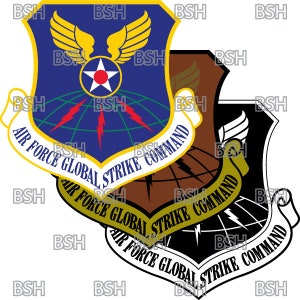 Può includere: Una toppa del Comando di Attacco Globale dell'Aeronautica Militare in blu e oro, con un globo, fulmini e ali. Il testo "Air Force Global Strike Command" è scritto su uno stendardo attorno al globo.