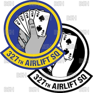 Puede incluir: Dos parches circulares. Uno es azul y amarillo, mostrando una mano sosteniendo cuatro cartas de juego '2', con el texto "327th Airlift SQ". El otro es una versión en blanco y negro del mismo diseño.