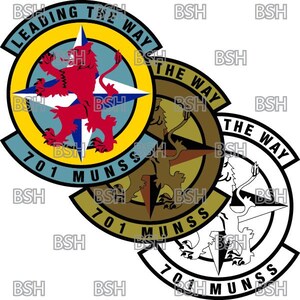 Peut inclure: Trois patchs circulaires avec une rose des vents et un motif de lion. Les patchs sont jaunes, bruns et blancs avec le texte "Leading the Way 701 MUNSS" sur chacun.