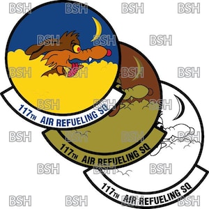 May include: A black and white emblem with a yellow, blue, and brown circle in the centre. The circle features a cartoon coyote with a crescent moon in the background. The text "117th AIR REFUELING SQ" is written around the circle.