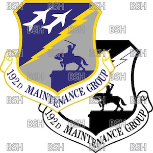 Könnte beinhalten: Ein blauer und grauer Schild mit gelbem Rand und einem Blitz. Zwei weiße Flugzeuge fliegen über dem Schild. Ein Reiter auf einem Pferd befindet sich in der Mitte des Schildes. Der Text "192D MAINTENANCE GROUP" ist auf einem weißen Banner um den Schild geschrieben.