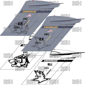 以下が含まれることがあります： グレーと白の飛行機の尾部で、「ANCHORAGE」と「AK 00185」の文字が書かれています。尾部には狼の頭部のグラフィックと小さなアメリカ国旗も描かれています。