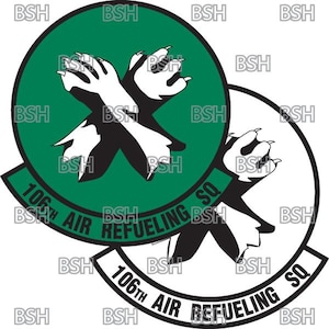 Op de afbeelding: Een zwart-witte afbeelding van twee gekruiste poten met klauwen, binnen een witte cirkel met de tekst "106th AIR REFUELING SQ". De afbeelding bevindt zich ook binnen een groene cirkel met de tekst "106th AIR REFUELING SQ".