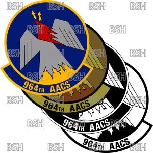 Op de afbeelding: Drie overlappende ronde patches met een geel, bruin, zwart en wit ontwerp. De patches tonen een gestileerde feniks met vlammen en de tekst "964th AACS".