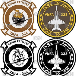 May include: Four circular embroidered patches featuring military aviation themes. Two patches display a rattlesnake coiled over an airplane with the text DEATH RATTLERS and VMFA-323. Two patches show a fighter jet with the text COME TO FIGHT COME TO WIN and VMFA-323. The designs are rendered in brown, black, white, and yellow color schemes.