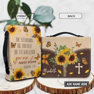 May include: A beige and brown Bible cover featuring sunflowers and butterflies. The front displays the text "BE STRONG, BE BRAVE, BE FEARLESS, you are never alone, Joshua 1:9." The back has sunflowers, a cross, and the name "Alizabeth."
