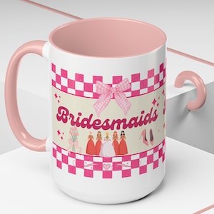 Puede incluir: Una taza de cerámica blanca con interior y asa de color rosa claro. El exterior presenta un borde a cuadros rosas y blancos, un lazo de guinga rosa y el texto "Bridesmaids" en letra cursiva rosa oscuro. Debajo, ilustraciones de una novia.