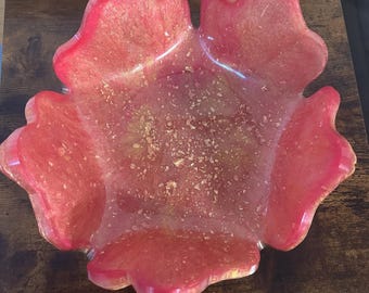 May include: A pink resin bowl with a flower-like shape and gold glitter embedded in the resin.