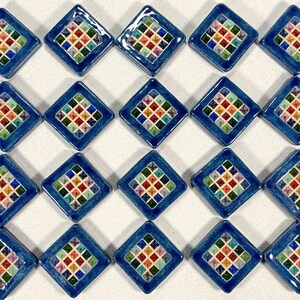 Puede incluir: Veinte azulejos cuadrados azules con un patr&oacute;n de diamante en el centro. El patr&oacute;n de diamante est&aacute; formado por cuadrados m&aacute;s peque&ntilde;os de varios colores, incluidos rojo, amarillo, verde y azul.