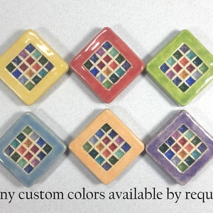 Puede incluir: Seis azulejos de cer&aacute;mica en forma de diamante con un dise&ntilde;o de mosaico en varios colores, incluyendo amarillo, rojo, verde, azul, naranja y morado. Los azulejos tienen un borde blanco y una forma de diamante central con cuadrados m&aacute;s peque&ntilde;os en varios colores. "many custom colors available by request" est&aacute; escrito debajo de los azulejos.