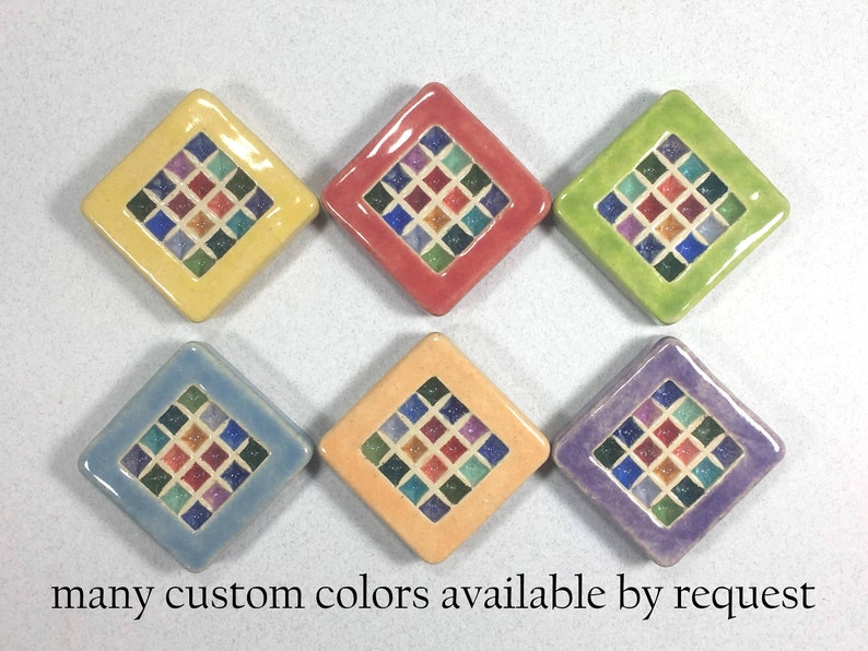 Puede incluir: Seis azulejos de cer&aacute;mica en forma de diamante con un dise&ntilde;o de mosaico en varios colores, incluyendo amarillo, rojo, verde, azul, naranja y morado. Los azulejos tienen un borde blanco y una forma de diamante central con cuadrados m&aacute;s peque&ntilde;os en varios colores. "many custom colors available by request" est&aacute; escrito debajo de los azulejos.