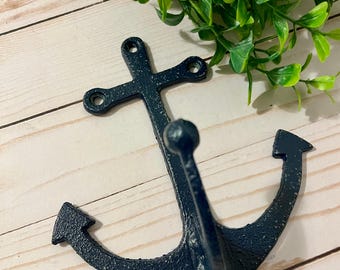May include: A dark blue cast iron anchor hook with a distressed finish. The hook is designed to resemble a traditional nautical anchor.