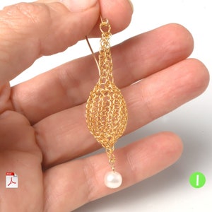 May include: Gold wire crochet earring with a white pearl dangle. The earring is made of a delicate, intricate design.