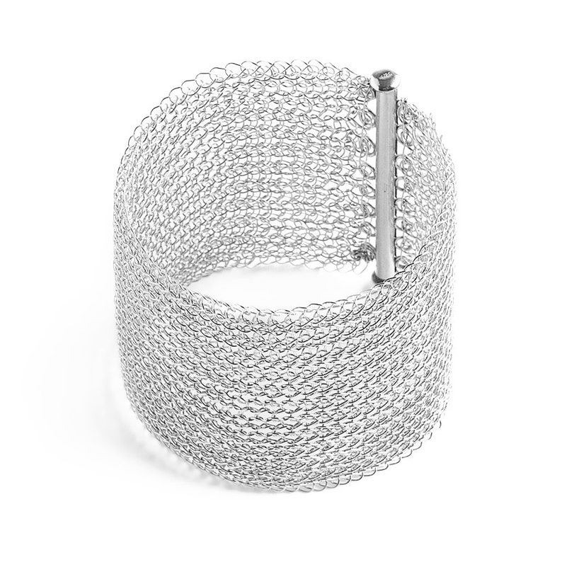 Puede incluir: Un brazalete de malla plateada con un cierre simple. El brazalete est&aacute; hecho de una malla fina y delicada, flexible y c&oacute;moda de llevar.