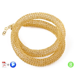 May include: A gold-toned necklace featuring a flexible, tubular mesh design with a woven, open-link structure. The piece is coiled into a circular shape and includes a short extender chain with small circular links at one end for adjustable length.