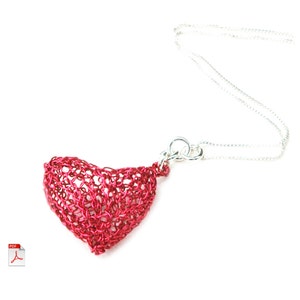 May include: A red wire heart pendant necklace with a silver chain. The heart is made of wire that is woven together to create a delicate and intricate design.