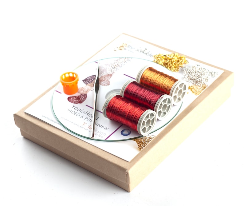 May include: A craft kit with three spools of copper wire in red and gold colors, a small orange plastic spool holder, and a CD with a printed label that says "YoolaHeart Tutorial VIDEO & PDF".