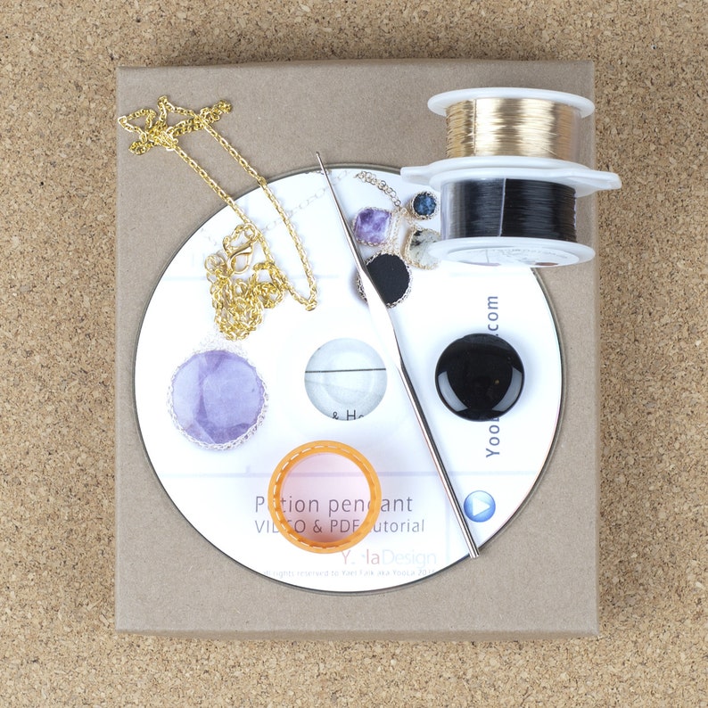 May include: A white CD with a gold chain, purple and black stones, a black and gold wire spool, and a silver crochet hook. The CD has the text "Potion pendant VIDEO & PDF tutorial" and "Y la Design".