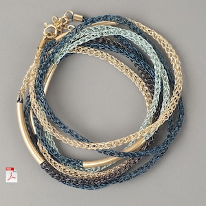 May include: A set of seven gold, blue and green wire bracelets with a gold bar accent. The bracelets are layered and intertwined.