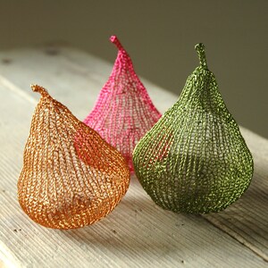May include: Three crocheted pear-shaped ornaments in gold, pink, and green.