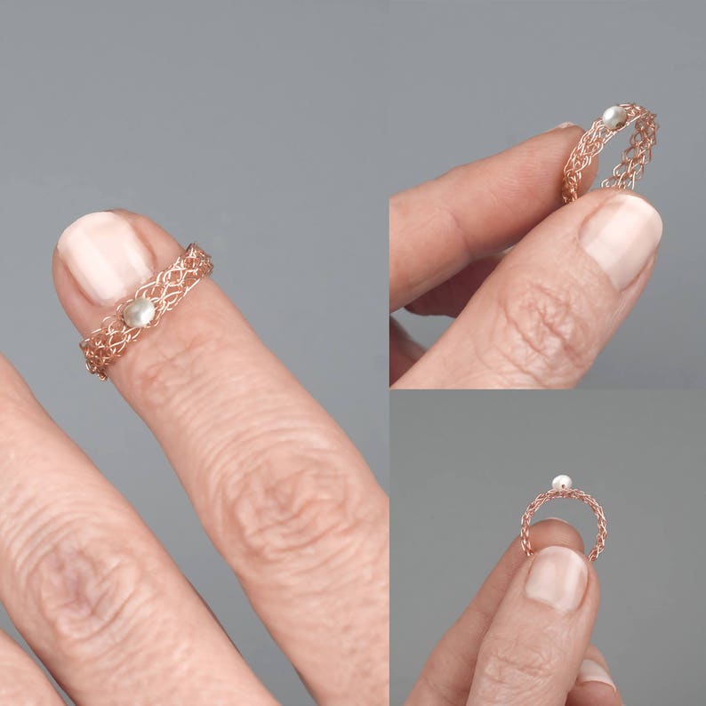 May include: A delicate rose gold ring with a small pearl accent. The ring is shown on a finger.
