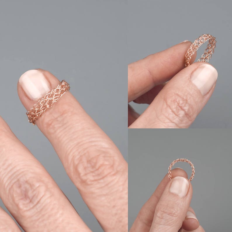 May include: A rose gold wire ring with a delicate, intricate design. The ring is shown on a finger.