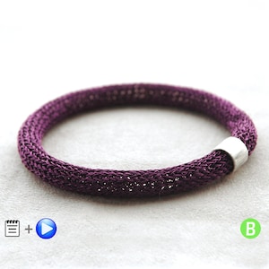May include: A purple knitted wire bracelet with a silver clasp.