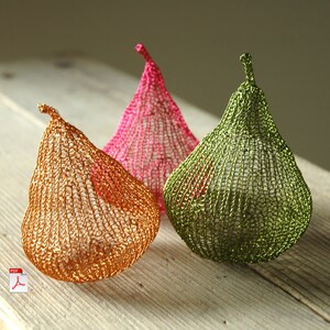 May include: Three crocheted pear-shaped ornaments in pink, green, and gold.