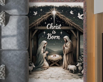 Puede incluir: Una manta tejida con una escena de la Natividad con el texto "Christ is Born". La imagen muestra a María, José y el niño Jesús en un pesebre, con estrellas, palomas y ovejas. La manta tiene un borde con flecos.