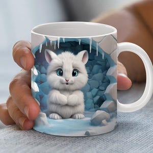 May include: White ceramic mug with a cartoon white cat with blue eyes peeking out of an ice cave. The cat is sitting with its paws crossed and has a friendly expression.