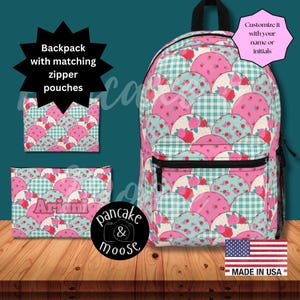 May include: A backpack and two matching zipper pouches featuring a repeating pattern of pink and teal scalloped circles with floral and plaid designs. One pouch displays the name Ariani. Text includes: Backpack with matching zipper pouches, Customize it with your name or initials, and MADE IN USA.