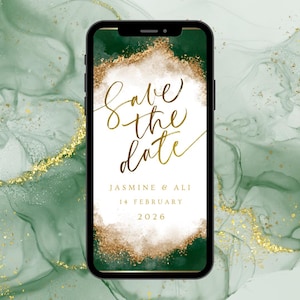 May include: A smartphone screen shows a digital wedding invitation. The invitation has gold script reading "Save the Date" over a white and gold design. The background is a green marble pattern with gold flecks. The date is 14 February 2026.