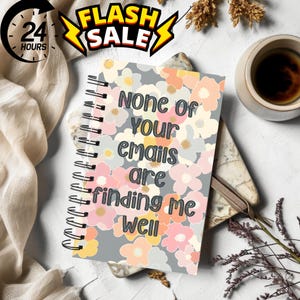 Może przedstawiać: Szary notes spiralny z kwiatowym wzorem i tekstem "None of your emails are finding me well".