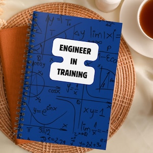 Può includere: Un quaderno a spirale blu con un adesivo bianco che dice "Engineer in Training". Il quaderno è coperto di equazioni matematiche e grafici scritti a mano.