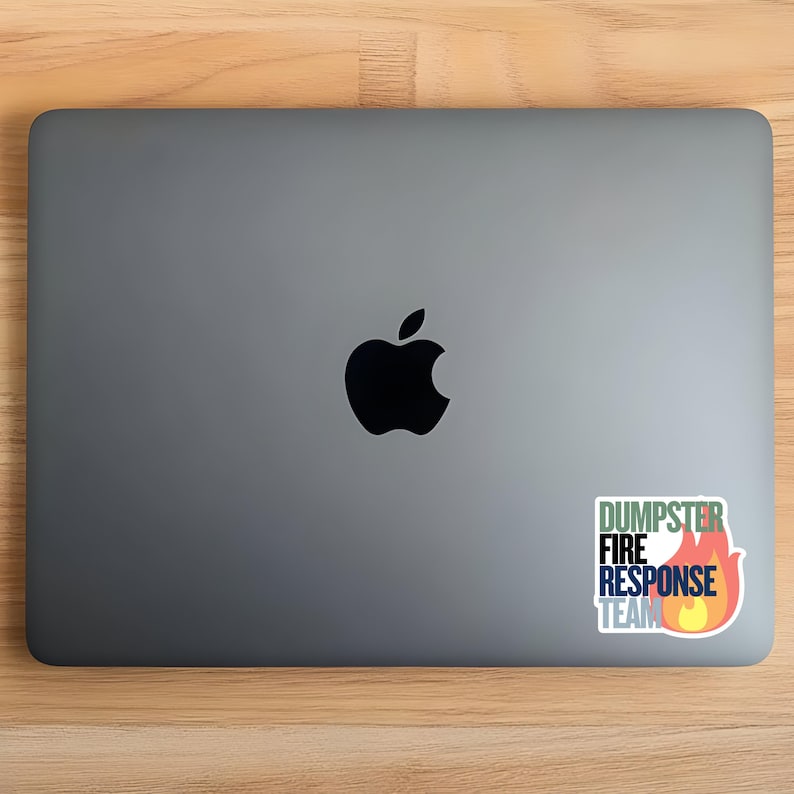 May include: A silver laptop with a black apple logo on the lid. A sticker on the right side of the laptop has the text 'DUMPSTER FIRE RESPONSE TEAM' in a multi-colored font with a flame icon.

Dumpster Fire Vinyl Sticker, Funny office gift for coworker, Dumpster Fire Response Team, vinyl waterproof sticker, office gag gift for boss