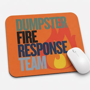 Może przedstawiać: Prostokątna podkładka pod mysz z pomarańczowym tłem i stylizowaną grafiką płomienia w kolorze czerwonym i ż&oacute;łtym. Napis DUMPSTER FIRE RESPONSE TEAM jest wydrukowany dużymi, pogrubionymi, wielokolorowymi literami blokowymi. Biała mysz komputerowa.