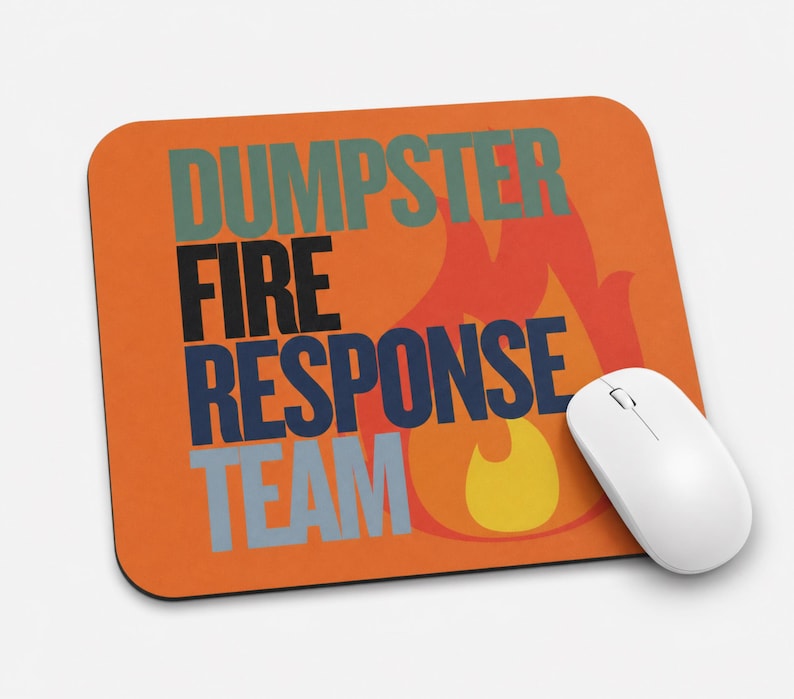 Może przedstawiać: Prostokątna podkładka pod mysz z pomarańczowym tłem i stylizowaną grafiką płomienia w kolorze czerwonym i ż&oacute;łtym. Napis DUMPSTER FIRE RESPONSE TEAM jest wydrukowany dużymi, pogrubionymi, wielokolorowymi literami blokowymi. Biała mysz komputerowa.