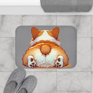 May include: A gray bath mat with a cartoon image of a corgi's rear end. The corgi is brown and white with a fluffy tail.