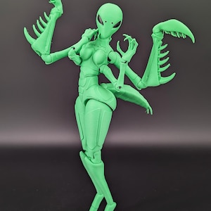 May include: A green articulated action figure of an alien insectoid humanoid. The figure has a smooth, matte finish and features multiple arms with claw-like appendages. The figure is posed against a dark background.